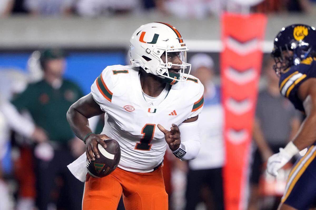 Oct 5, 2024; Berkeley, California, USA; Miami Hurricanes quarterback Cam Ward (1) scrambles against the California Golden Bears during the first quarter at California Memorial Stadium. Mandatory Credit: Darren Yamashita-Imagn Images
