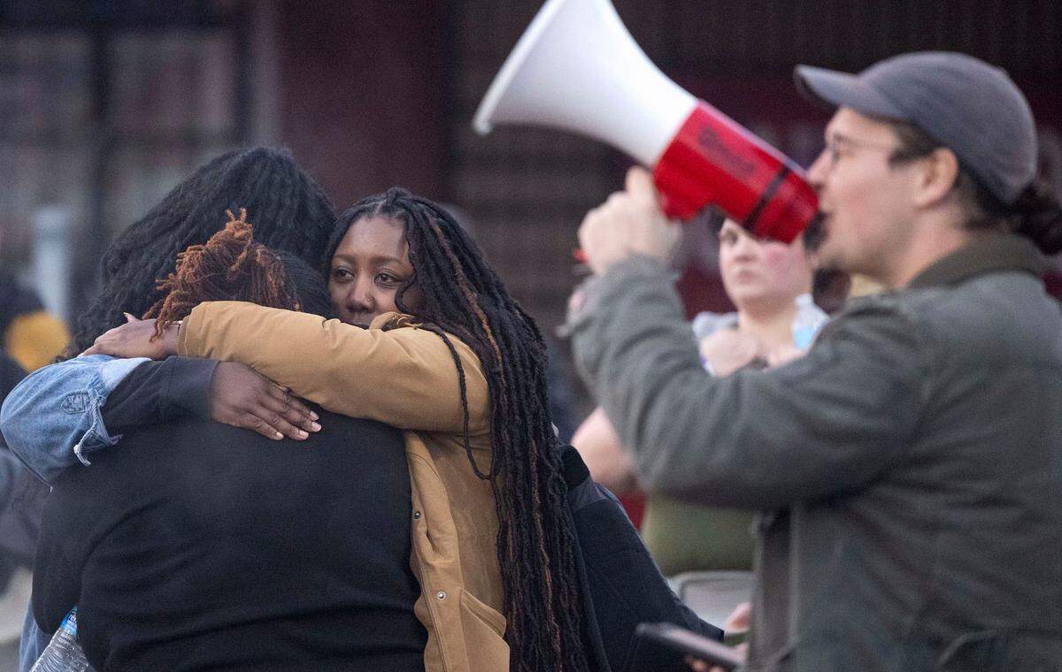 Protesters hug at the intersection of Martin Luther King Way and 11th Street in the Hilltop neighborhood of Tacoma, Wash., after three Tacoma Police officers were found not guilty in the death of Manuel Ellis on Thursday, Dec. 21, 2023.