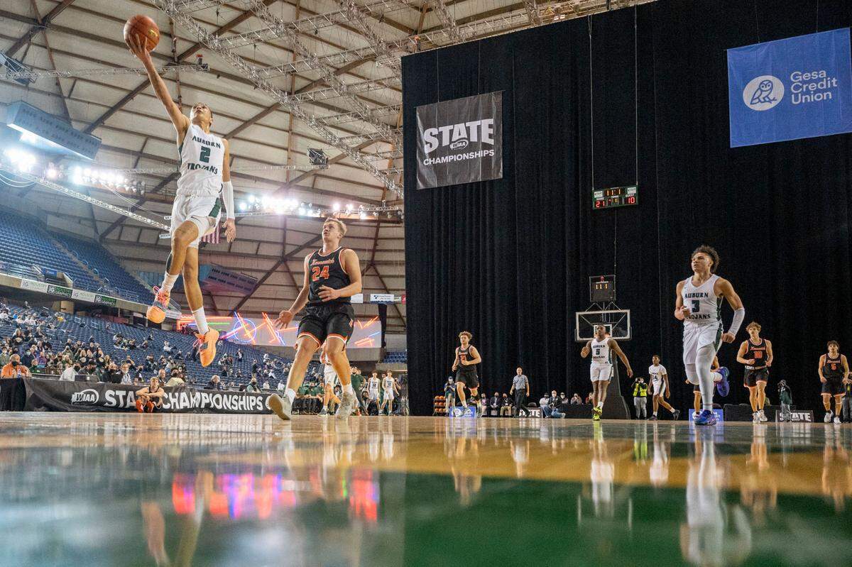 Auburn guard Trevon Blassingame (2) goes up for an uncontested fast-break layup as Kennewick Kennewick forward Ayden Knapik (24) gets back on defense during the first quarter of a Class 3A state tournament game on Wednesday, March 2, 2022, at the Tacoma Dome, in Tacoma, Wash.