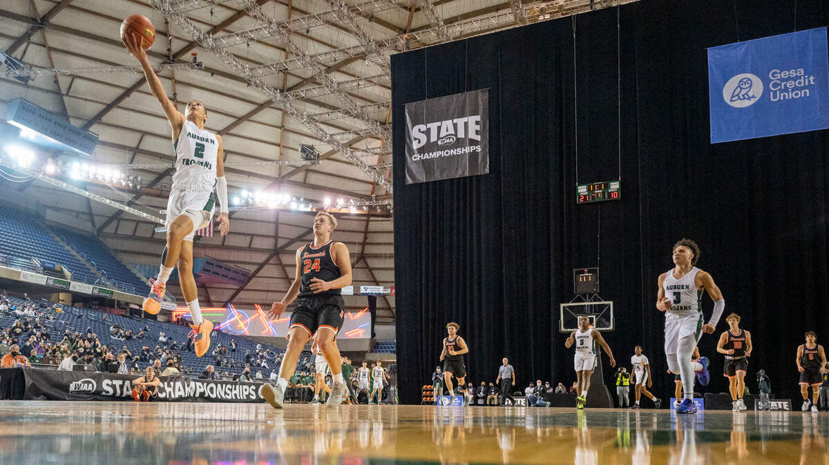 Auburn guard Trevon Blassingame (2) goes up for an uncontested fast-break layup as Kennewick forward Ayden Knapik (24) gets back on defense during the first quarter of a Class 3A state tournament game on Wednesday, March 2, 2022, at the Tacoma Dome, in Tacoma, Wash.