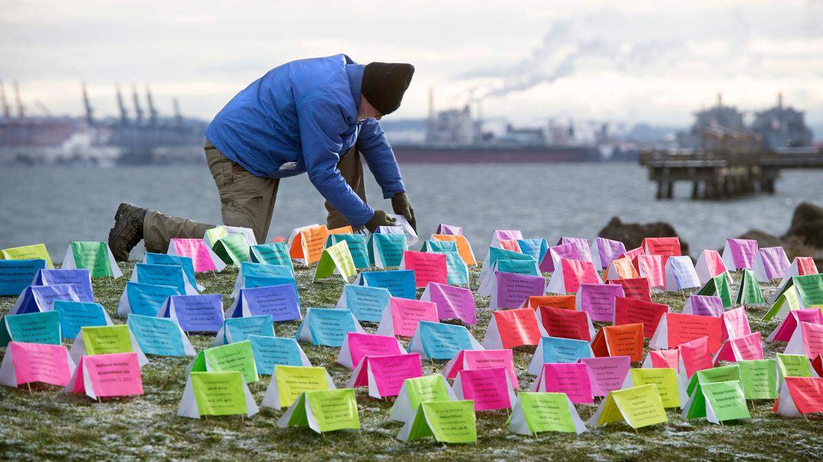 David Vance of Tacoma helps set up 167 paper “tents” to remember the 167 homeless people who died in Pierce County this year. The memorial was displayed in the morning at Judge Jack Tanner Park in Tacoma, Washington, on Wednesday, Dec. 21, 2022.