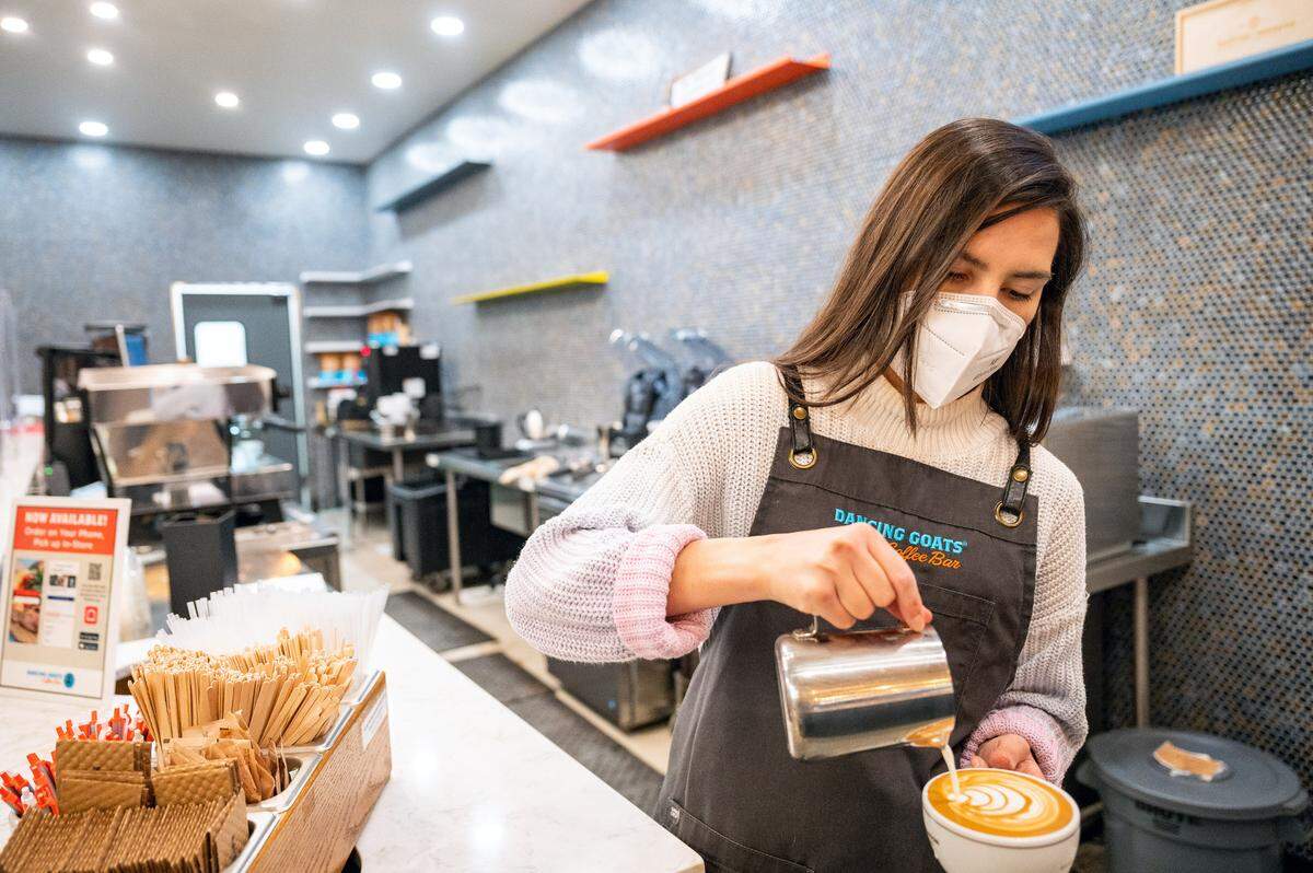 Dancing Goats Coffee manager Krystal Aguilera creates an artistic design as she pours cream onto a latte at the new downtown Tacoma coffee house on Friday, Jan. 21, 2022. Dancing Goats Coffee is located at 2102 Commerce St. in Tacoma.