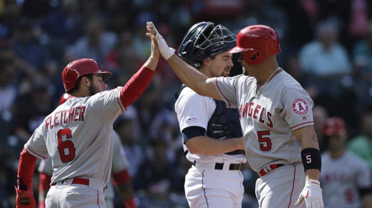 Los Angeles Angels’ David Fletcher greets Albert Pujols at home after the scored on Pujols’ home run against the Seattle Mariners during the first inning of a baseball game Saturday, June 1, 2019, in Seattle.