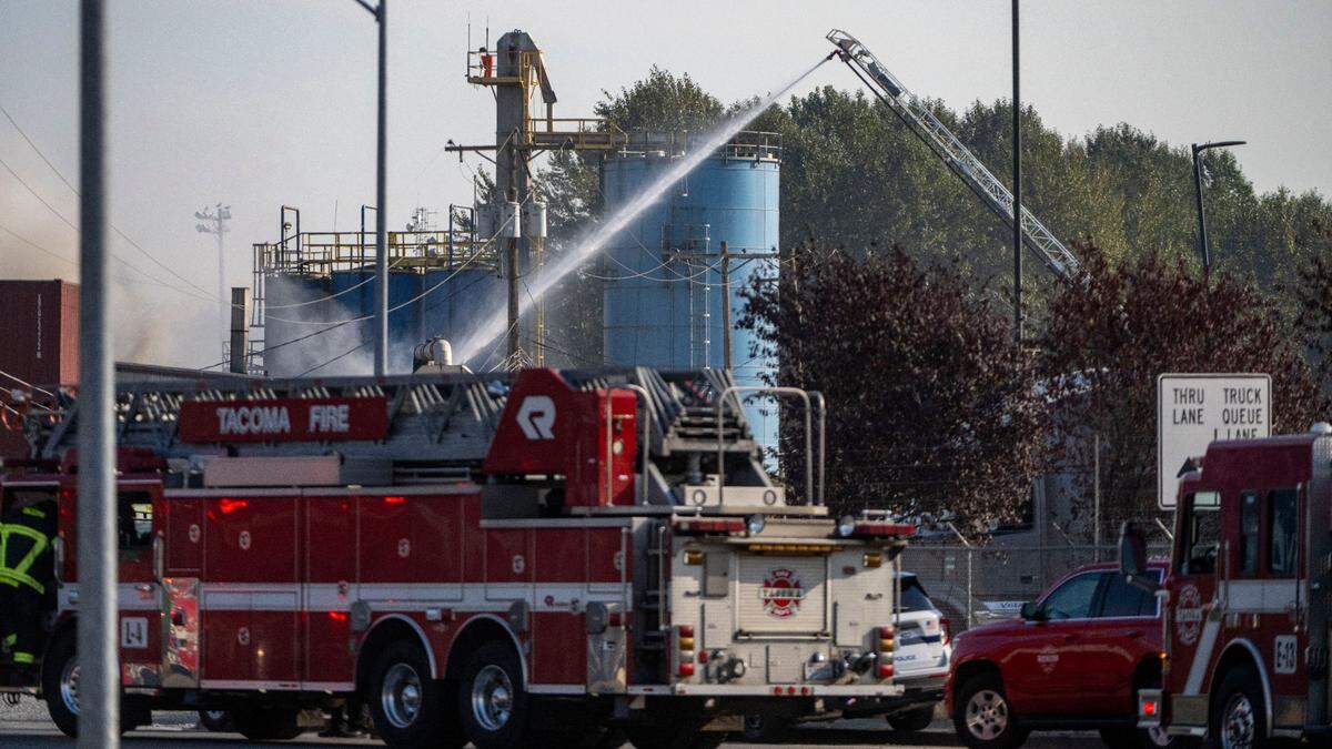 Firefighters from the Tacoma Fire Department utilize a ladder truck to spray water onto a blaze at Darling Ingredients on the 2000 block of Marc Avenue near the Port of Tacoma on Tuesday, Sept. 27, 2022.