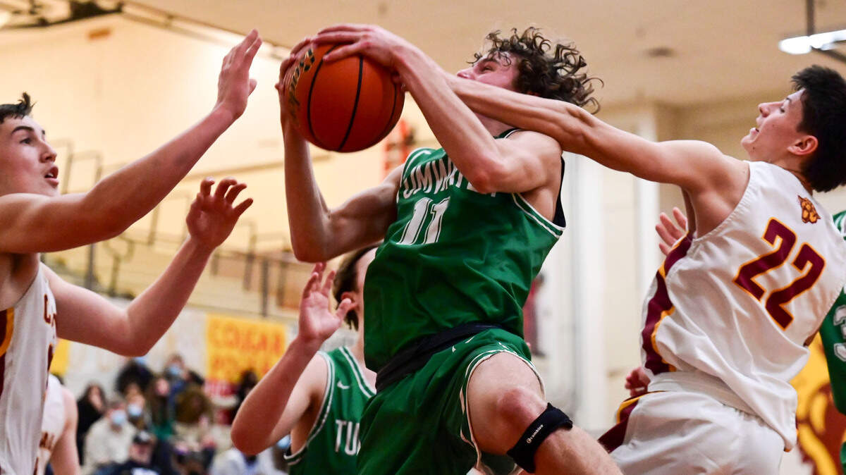 Tumwater guard Luke Brewer (11) grabs an offensive rebound away from Capital guard Carl Schreck (22) during the third quarter of a non-league game in Olympia on Saturday, Jan. 22, 2022.