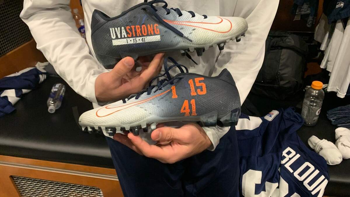 Seahawks rookie safety Joey Blount holds the special cleats he wore in Seattle’s game Nov. 27 to honor and remember Lavel Davis Jr., Devin Chandler and D’Sean Perry, three of Blount’s former University of Virginia teammates who were shot and killed on campus in Charlottesville Nov. 13, 2022.