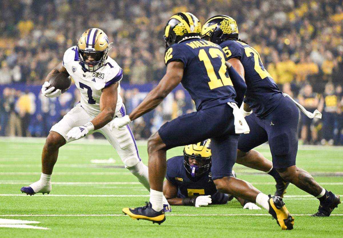 Washington Huskies running back Dillon Johnson (7) carries the ball during the first quarter of the College Football Playoff National Championship game against the Michigan Wolverines at NRG Stadium on Monday, Jan. 8, 2024, in Houston.