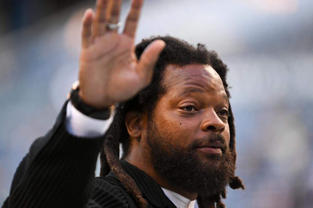 Former Seattle Seahawk Michael Bennett waves to fans before of the preseason game against the Minnesota Vikings at Lumen Field, Thursday, Aug. 10, 2023, in Seattle. Bennett is a commentator and interviewer for Seahawks preseason television broadcasts this month.