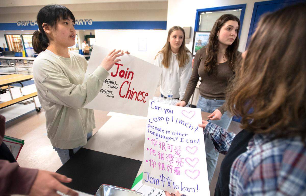 Gig Harbor High junior Anna Daetwiler (from left), 17, freshman Maddie Powell, 15, sophomore Sasha Unger, 16, and freshman Ivy Goodkin, 14, prepare an information booth for their recruitment event for the district’s Chinese language program at Kopachuck Middle School in Gig Harbor, Washington, on Friday, April 29, 2022.