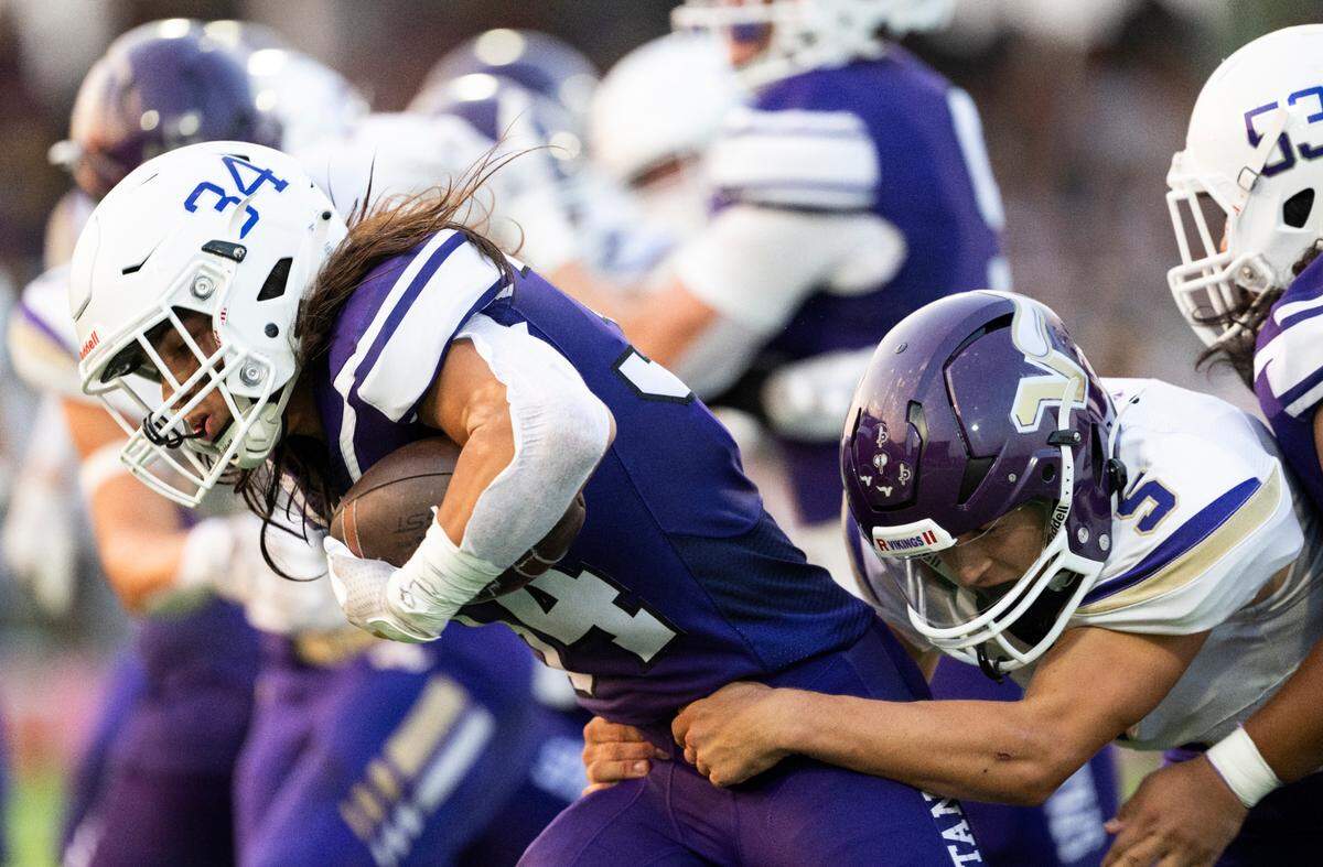 Sumner’s Steele Isaacs (34) carries the ball against Lake Stevens’ Treyten Pester (5) during the first half of the game at Sumner High School, on Friday, Sept. 6, 2024, in Sumner, Wash.