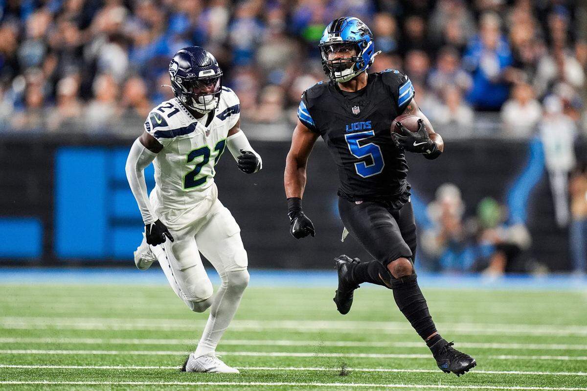 Detroit Lions running back David Montgomery (5) runs against Seattle Seahawks cornerback Devon Witherspoon (21) during the first half at Ford Field in Detroit on Monday, Sept. 30, 2024.