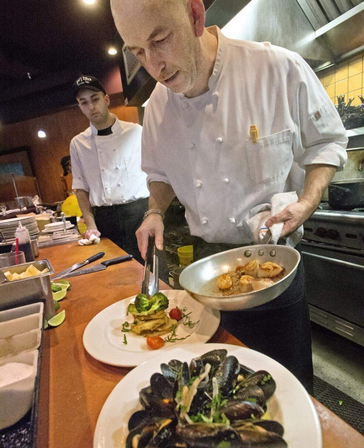 You’ll still find McManus on the line. Here he prepares scallops and Kamilche Sea Farms mussels at the old restaurant in January 2013. | TNT Staff File, Peter Haley