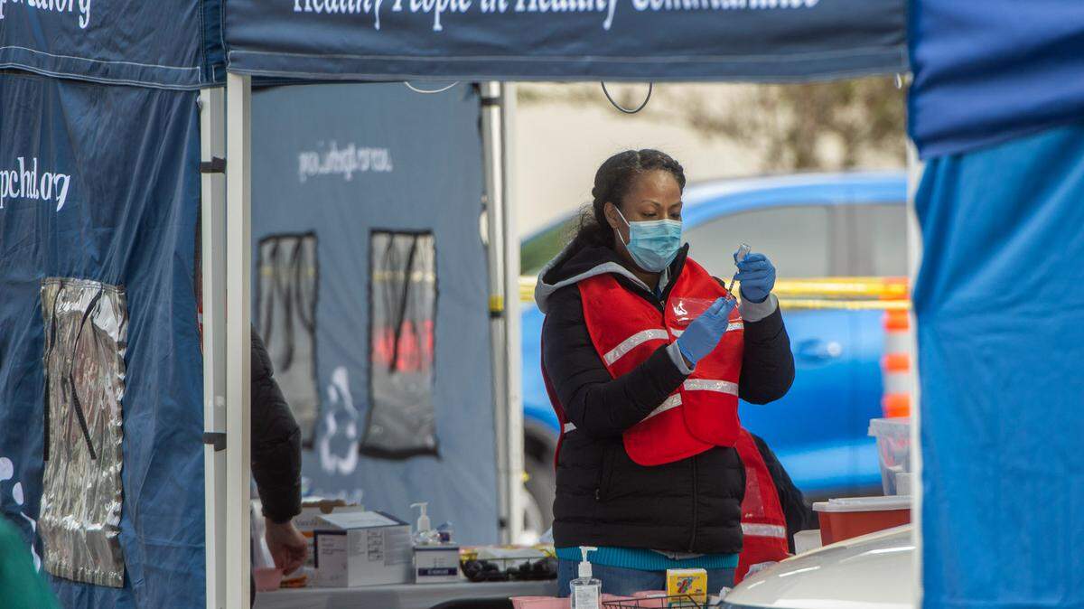 Registered nurse Nancy Thompkins loads a syringe with the Moderna vaccine at one of the drive-thru bays at Pierce County’s first free mass immunization clinic held Tuesday, Jan. 26, 2021 at Clover Park Technical College in Lakewood. The vaccine requires a second booster shot four weeks later.