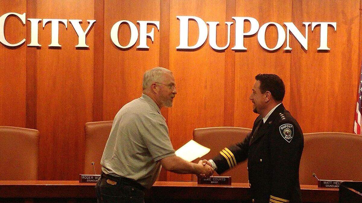Dupont mayor Mike Courts, left, swears in Larry Holt as police chief on May 26, 2017. On Wednesday, the City of Dupont announced Holt is resigning to "pursue other opportunities both professional and personal."