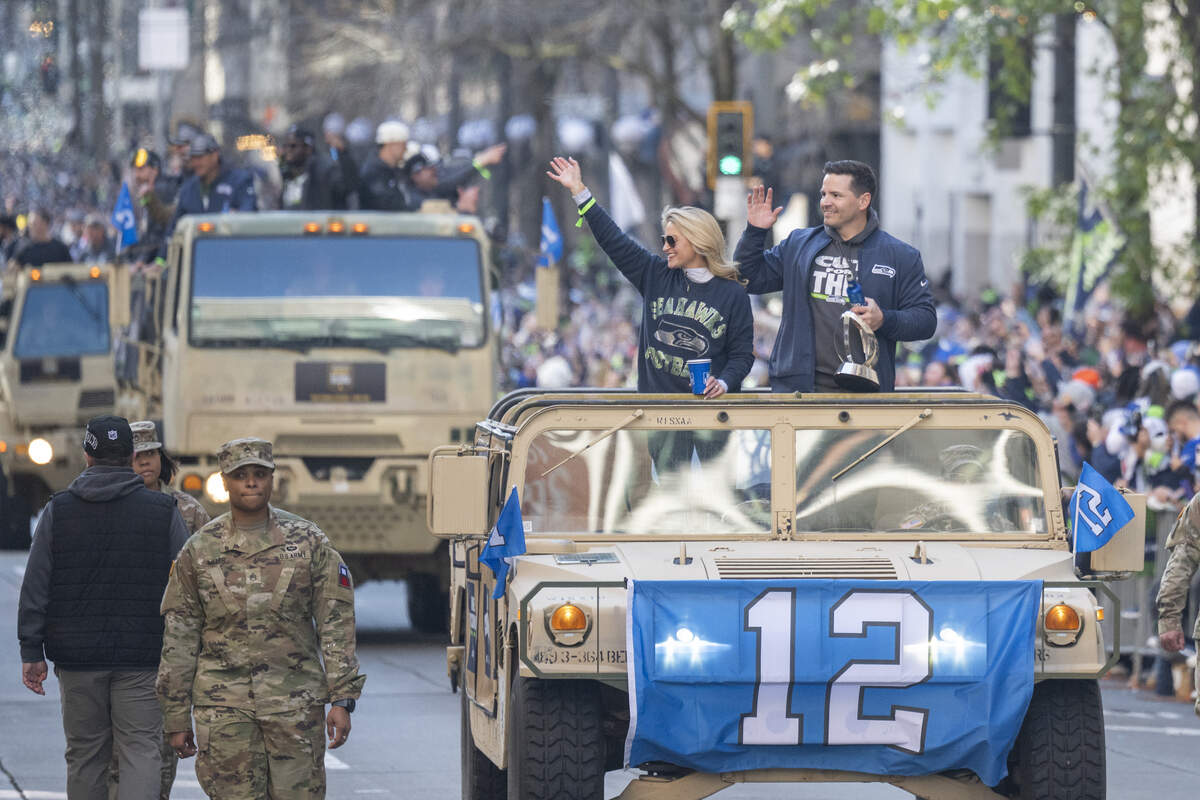 Seahawks head coach Mike Macdonald and his wife Stephanie (left) wave to fans during the team’s Super Bowl 60 victory parade through downtown Seattle on Wednesday, Feb. 11, 2026.