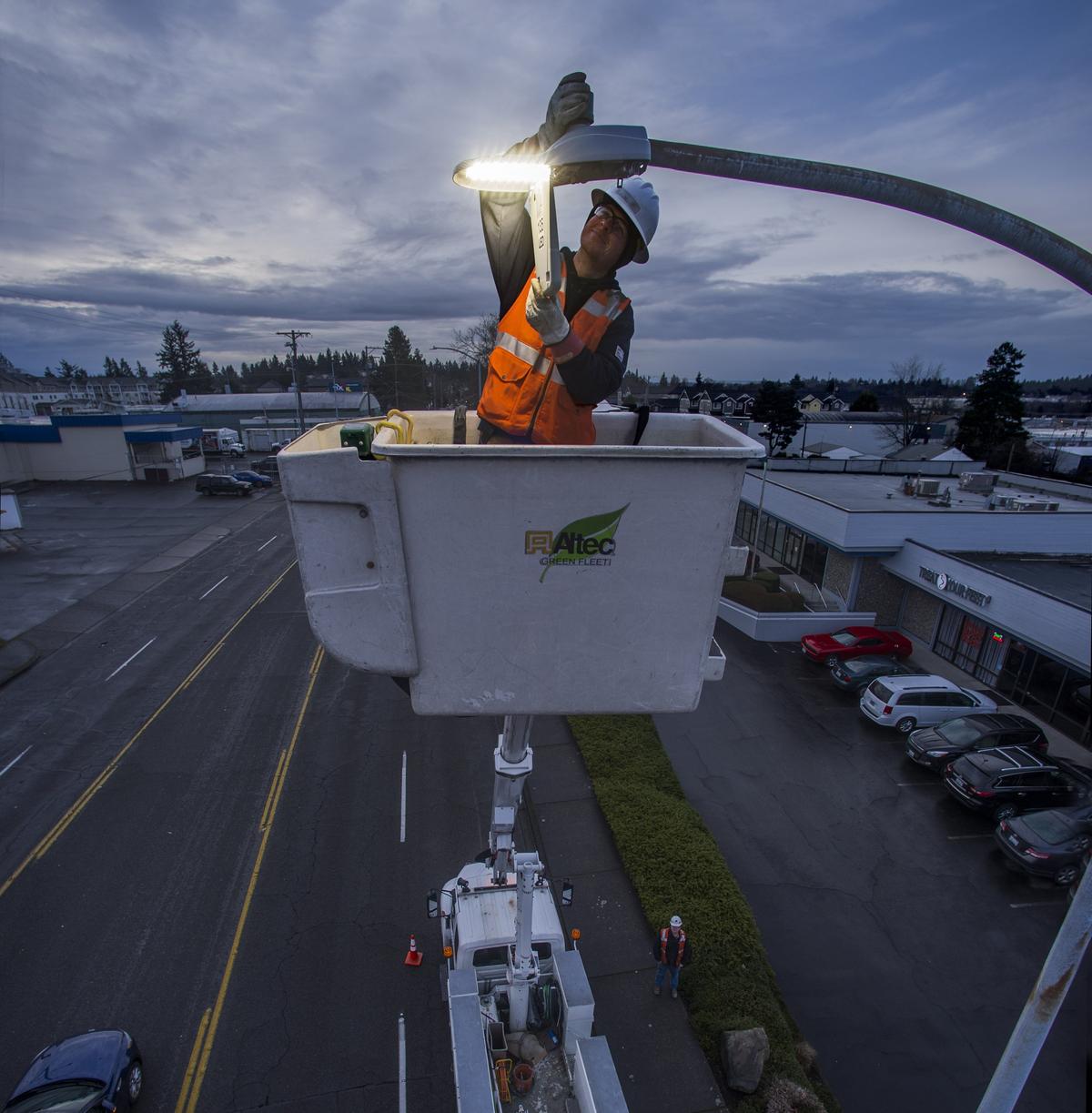 Gary Baublitz, a signal-streetlight apprentice with Tacoma Public Utilities, covers the sensor to turn on a newly-installed LED streetlight near S. 38th street, January 18, 2019.