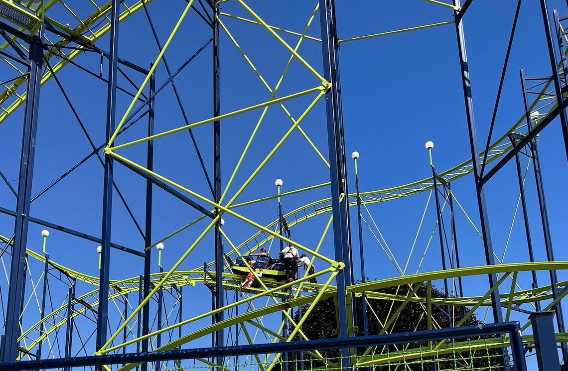 Ride operators push a car with passengers stuck in it, mid-ride on the Wildcat roller coaster at the Washington State Fair in Puyallup, Sept. 1, 2023.