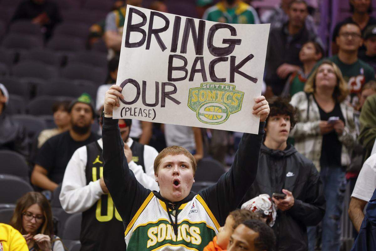 Oct 10, 2023; Seattle, Washington, USA; A Seattle Supersonics fan holds a sign advocating for their return during pregame warmups between the LA Clippers and Utah Jazz at Climate Pledge Arena. Mandatory Credit: Joe Nicholson-USA TODAY Sports