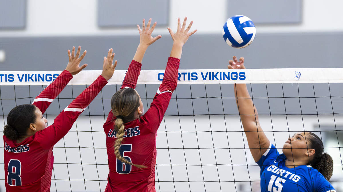 Curtis right side/middle blocker Kayla Baker (15) hits the ball against Kennedy Catholic outside hitter Acacia Lloyd-Aguiar (8) andmiddle blocker Pela Ivey (6) during the volleyball match at Curtis Senior High School, on Thursday, Sept. 18, 2025, in University Place, Wash.