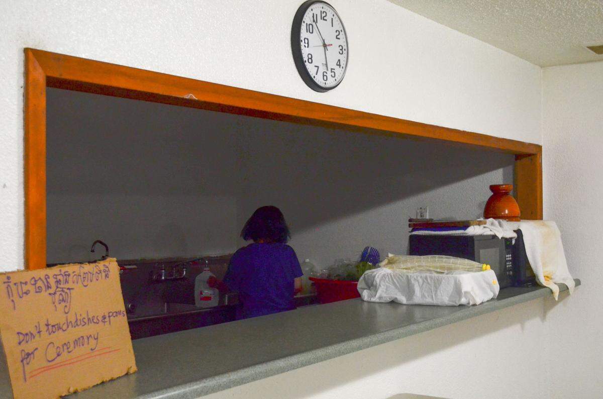 The woman who was arrested for allegedly attacking a nun at Khmer Theravadin Buddhist Temple last week fills a jug of water in the basement of the temple Monday, Sept. 28, 2021.