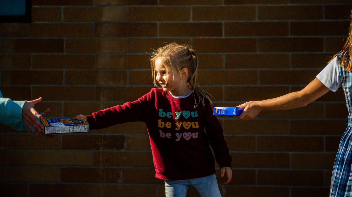 Kindergartner Chloie Phillips passes along cans of soup during the St. Nicholas Catholic School food collection in October. The school’s principal was fired last week