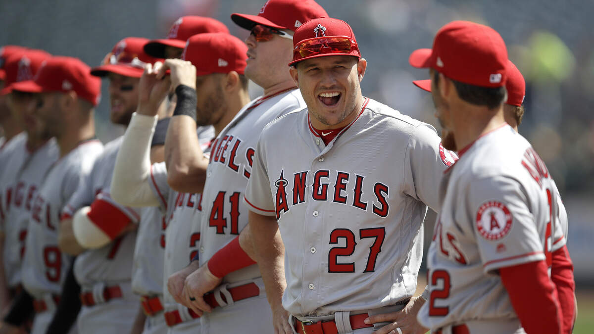 Los Angeles Angels’ Mike Trout (27) laughs with teammates prior to an opening day baseball game against the Oakland Athletics, Thursday, March 28, 2019, in Oakland, Calif. (AP Photo/Ben Margot)