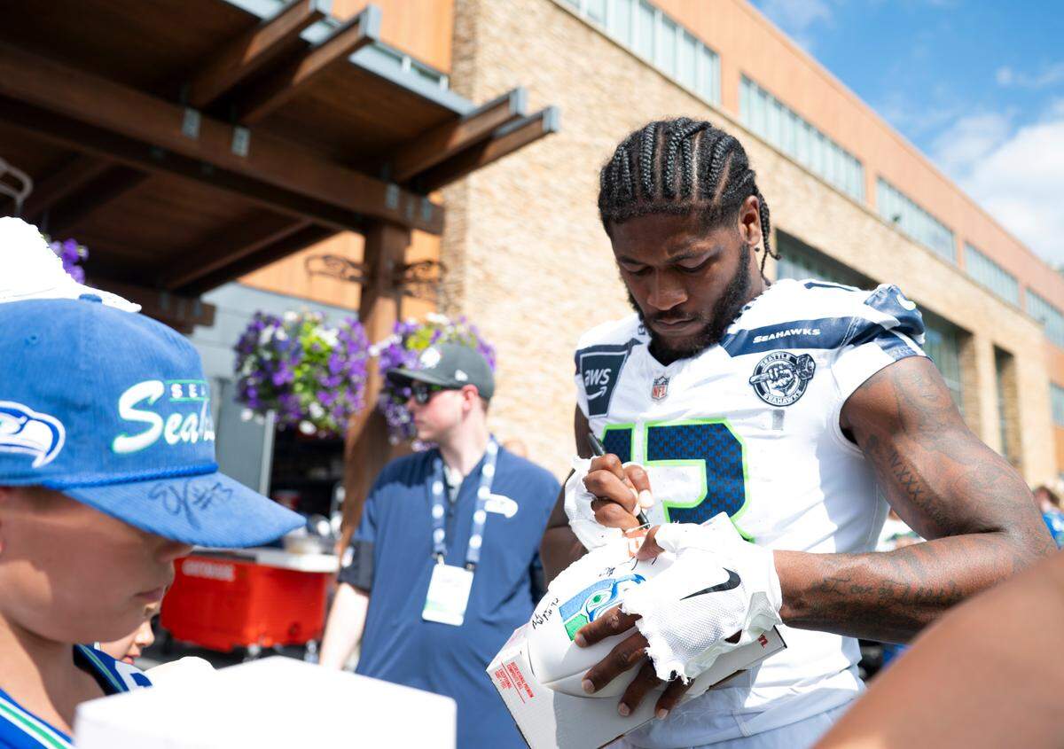 Seattle Seahawks linebacker Ernest Jones IV (13) signs autographs after training camp at Virginia Mason Athletic Center on Friday, July 25, 2025, in Renton.