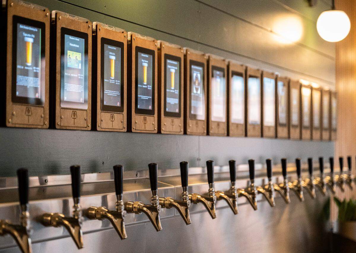 At The Living Taproom, customers start a tab with a host, then tap their wristband to pour a drink of their choice at the iPourIt system.