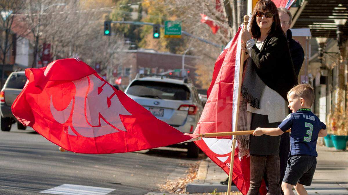 Bradley Harris, 3, waves a WSU flag while waiting for the ESPN College GameDay trucks on Wednesday, Oct. 17, 2018, in downtown Pullman, Wash. ESPN’s “College GameDay” is in Pullman on Saturday ahead of No. 25 Washington State’s Pac-12 showdown with No. 12 Oregon and it could be unlike any setting ever for college football’s version of Woodstock. (Geoff Crimmins/Moscow-Pullman Daily News via AP)