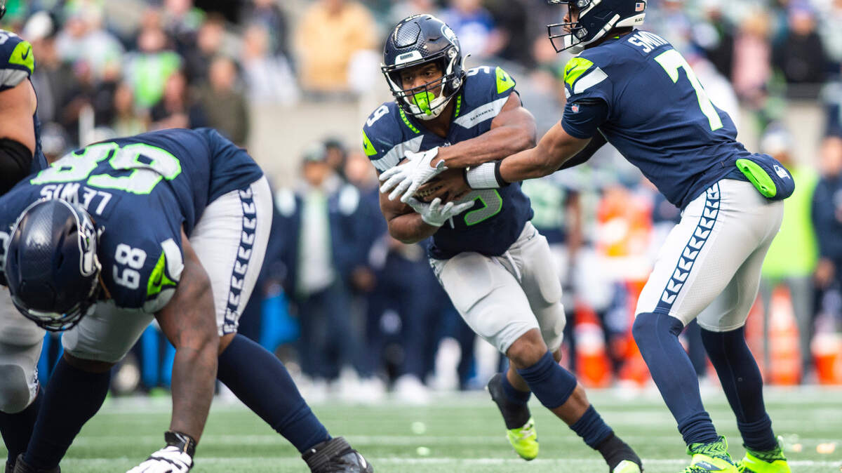 Seattle Seahawks quarterback Geno Smith (7) hands the ball off to Seattle Seahawks running back Kenneth Walker III (9) in the first quarter of an NFL game against the New York Jets at Lumen Field in Seattle Wash. on Jan. 1, 2023. The Seahawks defeated the Jets 23-6.