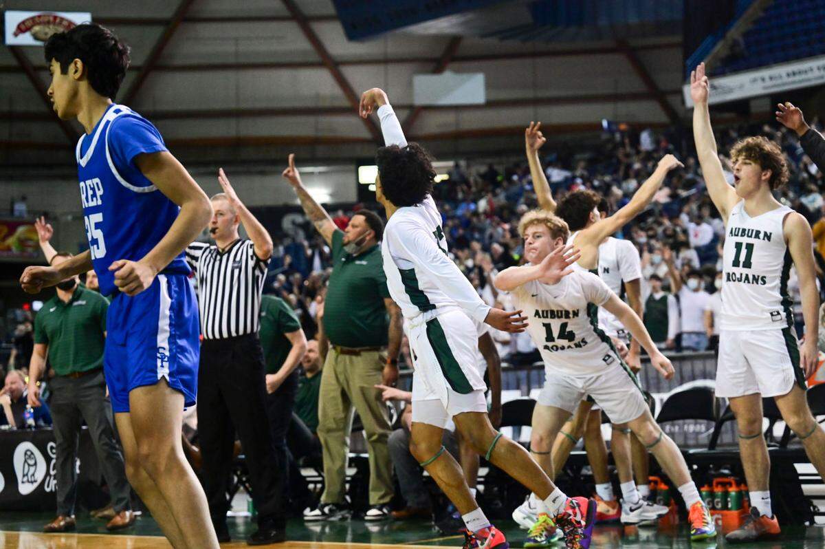 The Auburn bench celebrates after forward Tyrell Nichols (13) sunk a 3-pointer from the corner as Seattle Prep guard Nirvaan Misra (25) jogs down the court during the third quarter of a Class 3A semifinal state tournament game on Friday, March 4, 2022, at the Tacoma Dome, in Tacoma, Wash.
