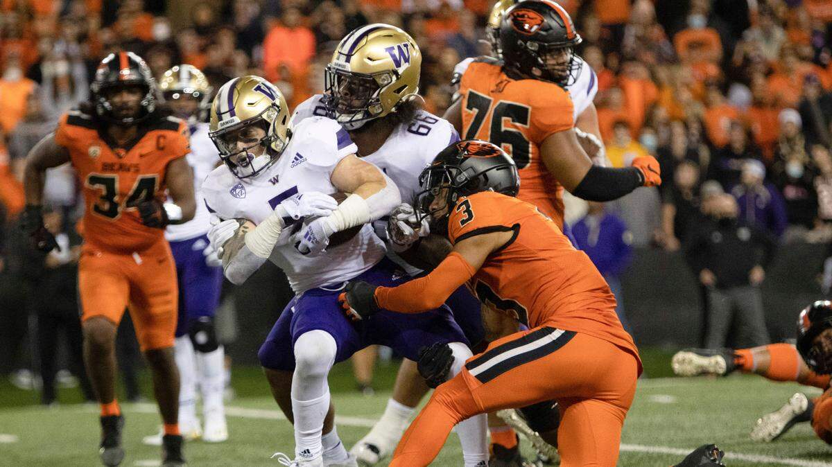 Washington offensive linesman Henry Bainivalu (66) helps push running back Sean McGrew (5) past Oregon State defensive back Jaydon Grant (3) and into the end zone for a touchdown during the second half of an NCAA college football game Saturday, Oct. 2, 2021, in Corvallis, Ore. Oregon State won 27-24. (AP Photo/Amanda Loman)