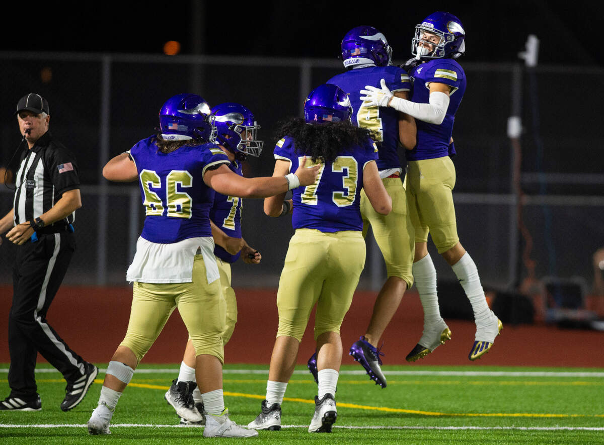 Puyallup wide receiver Kai Richardson (14) celebrates with Puyallup wide receiver Dane Parker (4) after scoring a touchdown in the third quarter of a game against Olympia at Sparks Stadium in Puyallup, Wash. on Oct. 6, 2022. Puyallup defeated Olympia 29-24.