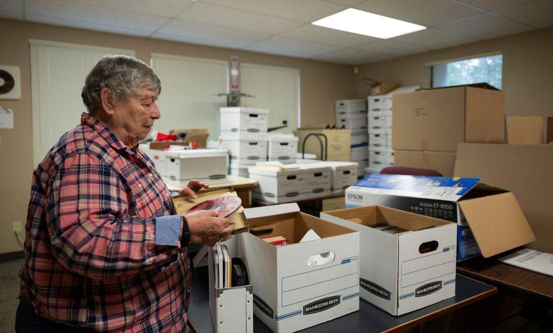 President JoAnn Taylor looks through old boxes of historical items at the Greater Bonney Lake Historical Society on Tuesday, May 21, 2024, in Bonney Lake.