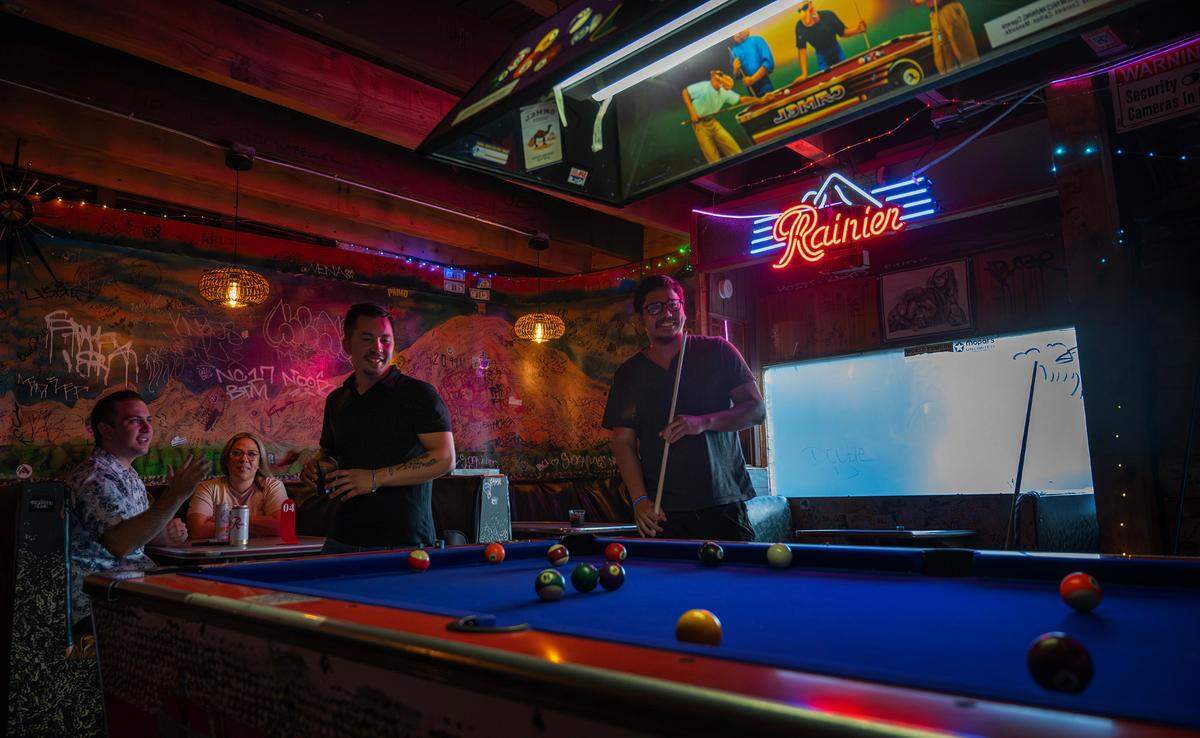 Benito Catibog (left) and Jomi Rios play a game of pool on the table that made an appearance in the movie, “I Love You to Death,” at the historic Bob’s Java Jive tavern in Tacoma, Washington, shown on Monday, July 1, 2024.