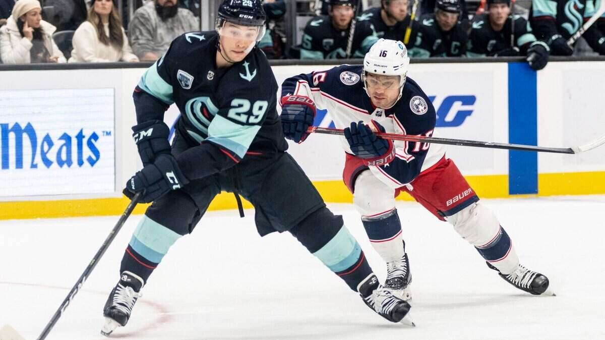 Seattle Kraken defenseman Vince Dunn (29) and Columbus Blue Jackets center Max Domi battle for the puck during the first period of an NHL hockey game, Saturday, Dec. 11, 2021, in Seattle. (AP Photo/Stephen Brashear)
