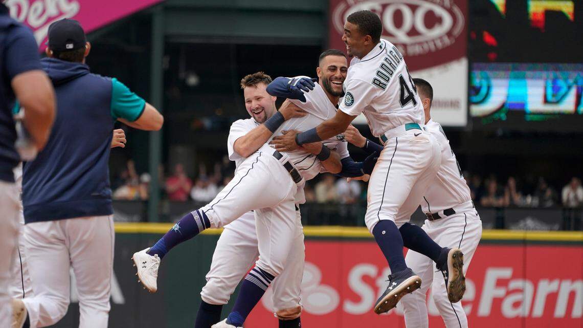 Seattle Mariners’ Abraham Toro, center, is greeted by Julio Rodriguez, right, and Cal Raleigh, left, after Toro hit a single to score Marcus Wilson with the winning run against the Oakland Athletics during the ninth inning of a baseball game, Saturday, July 2, 2022, in Seattle. The Mariners won 2-1. (AP Photo/Ted S. Warren)