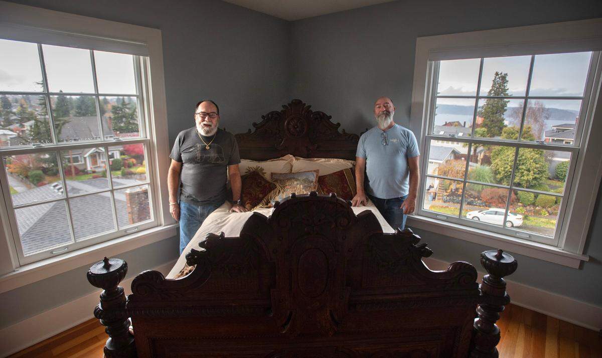 Gray Mansion owners Jose Santiago-Cummings (left) and Jeffrey Sawyer in one of the bedrooms with corner views of Commencement Bay in Tacoma on Thursday, Nov. 14, 2024. The spacious and historic 1908 mansion is listed for sale at $1.75 million.