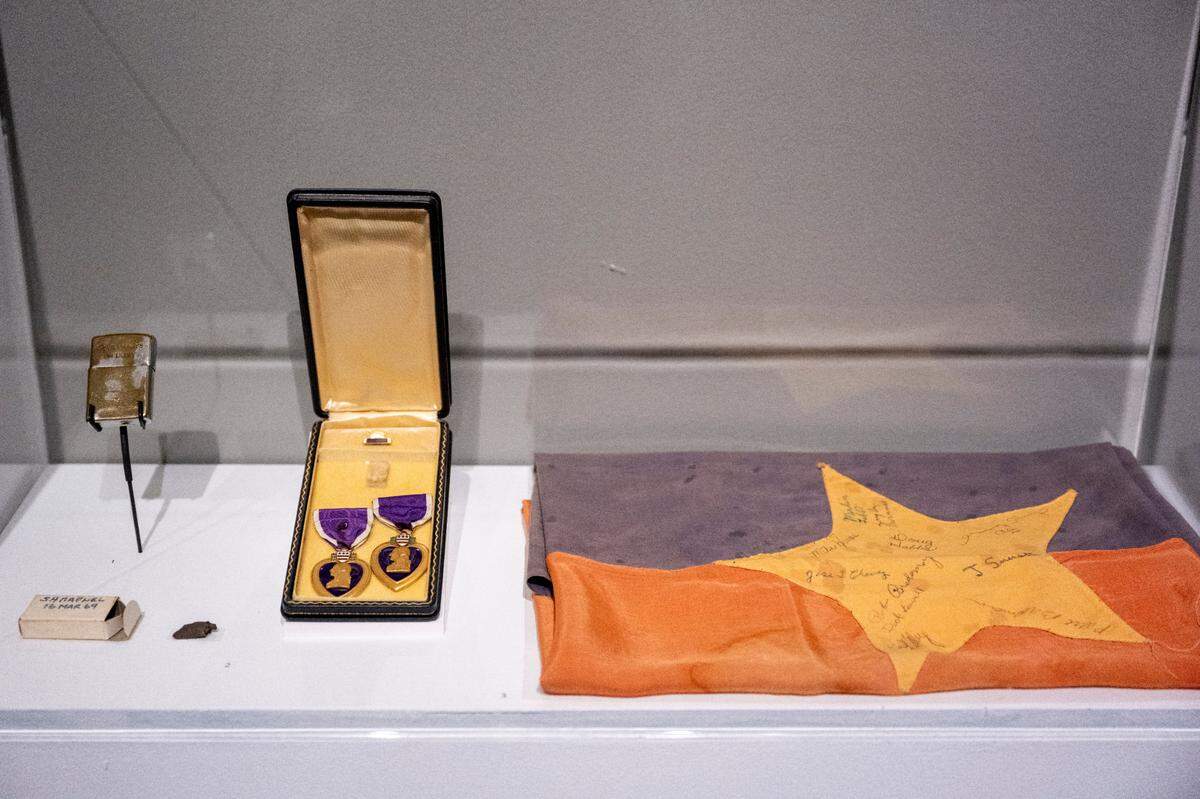 Personal objects brought back from Washington Vietnam War veterans’ service sit on display at the new exhibit “The Things They Brought Home,” at the Washington State History Museum on Thursday, April 24, 2025, in Tacoma. Included in this display case are, from left to right, an engraved Zippo lighter, a piece of shrapnel and the Purple Heart awarded for the shrapnel injury and a North Vietnamese Army flag.