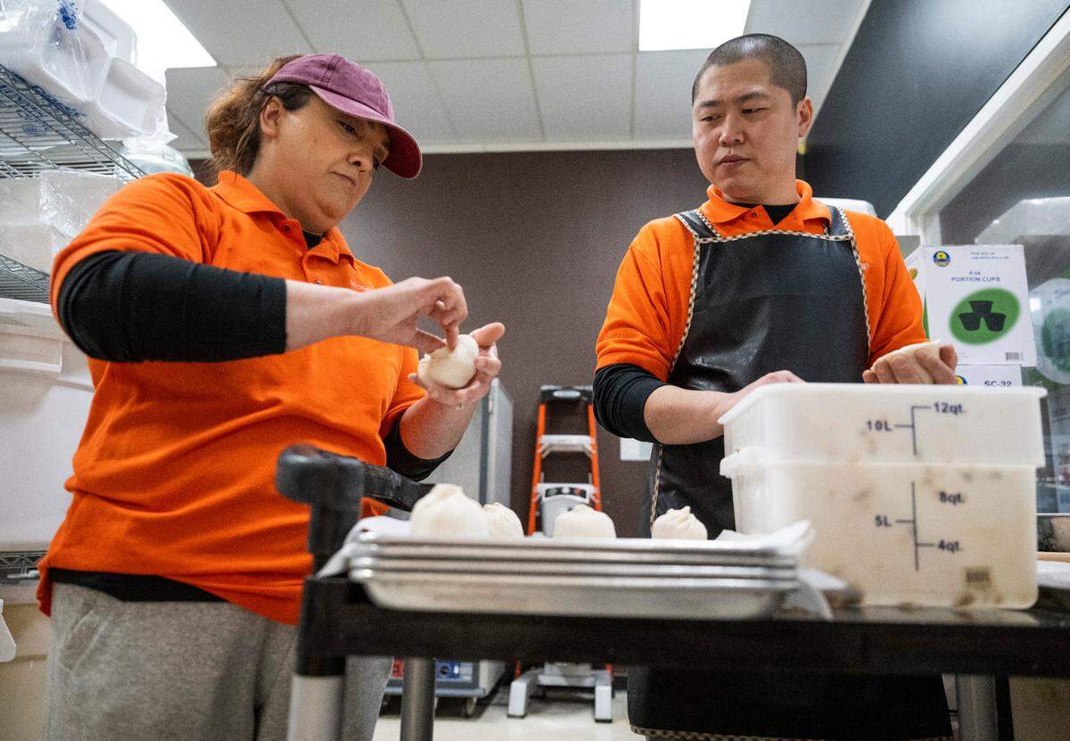 Myungln Dumplings co-owners Kelly Jin, left, and her husband, Dong “Bobo” Xiang Jin, right, make fresh dumplings at the restaurant in Lakewood, Wash. on Oct. 3, 2022.