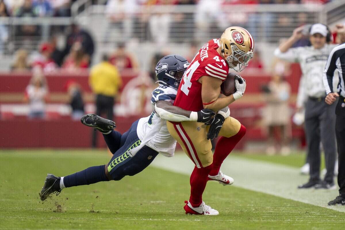 November 17, 2024; Santa Clara, California, USA; San Francisco 49ers fullback Kyle Juszczyk (44) is tackled by Seattle Seahawks linebacker Tyrice Knight (48) during the second quarter at Levi's Stadium. Mandatory Credit: Kyle Terada-Imagn Images