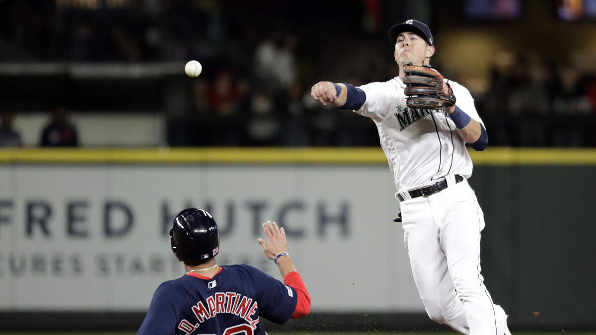 Seattle Mariners third baseman Dylan Moore throws to first base after forcing out Boston Red Sox’s J.D. Martinez at second base in a baseball game Saturday, March 30, 2019, in Seattle. (AP Photo/Elaine Thompson)