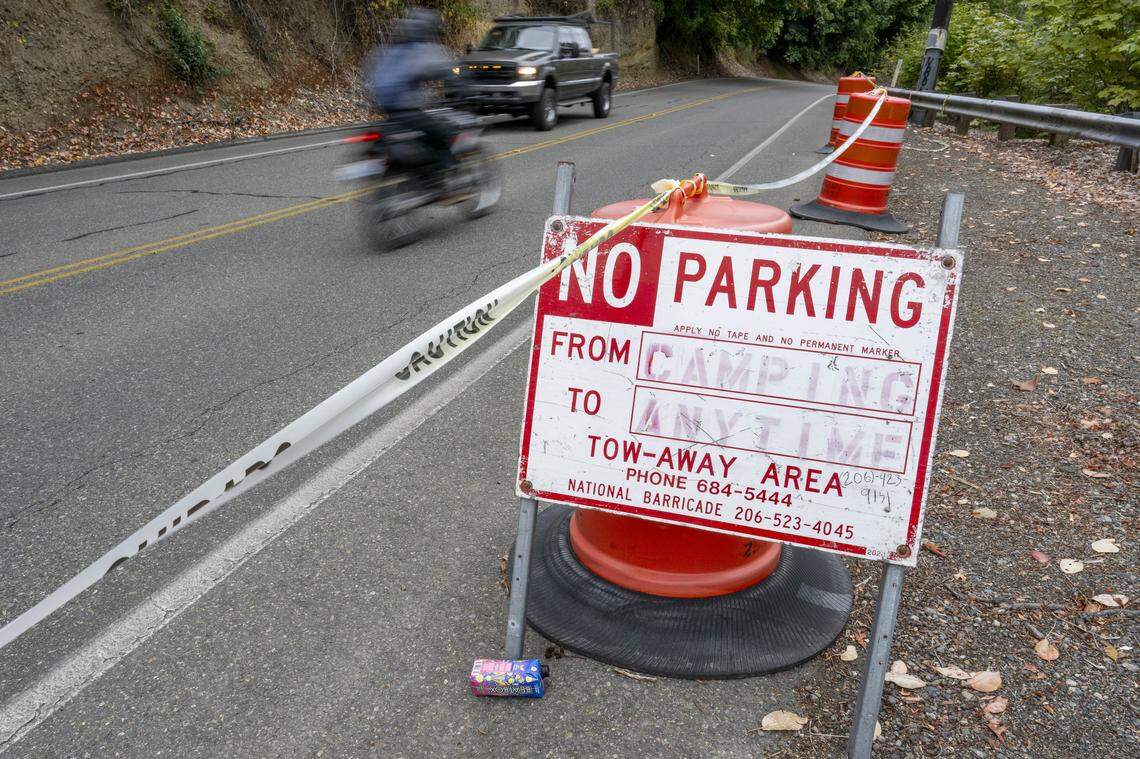 Vehicles pass by traffic barrels and signs prohibiting parking and camping along Marine View Drive on Thursday, Aug. 7, 2025, in Tacoma, Wash.