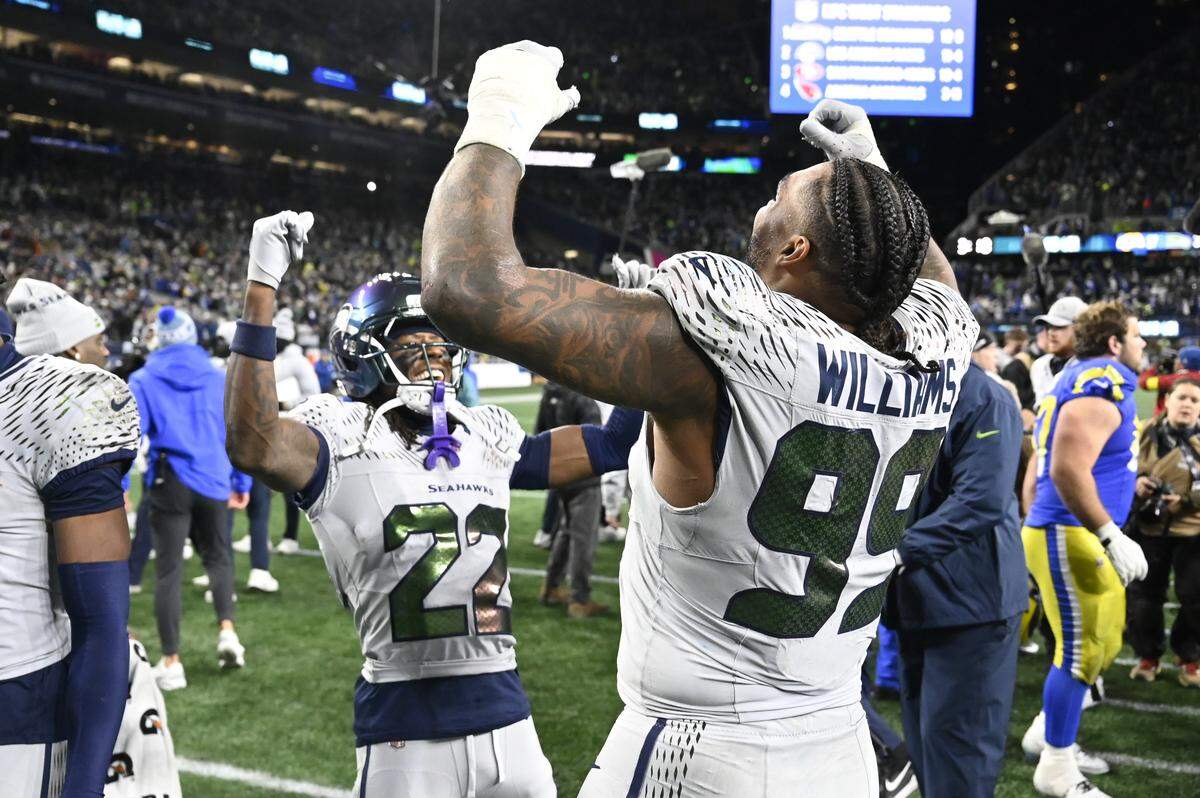 Seattle Seahawks wide receiver Rashid Shaheed (22) and Seattle Seahawks defensive end Leonard Williams (99) celebrate their win over the Los Angeles Rams at Lumen Field, on Thursday, Dec. 18, 2025, in Seattle.