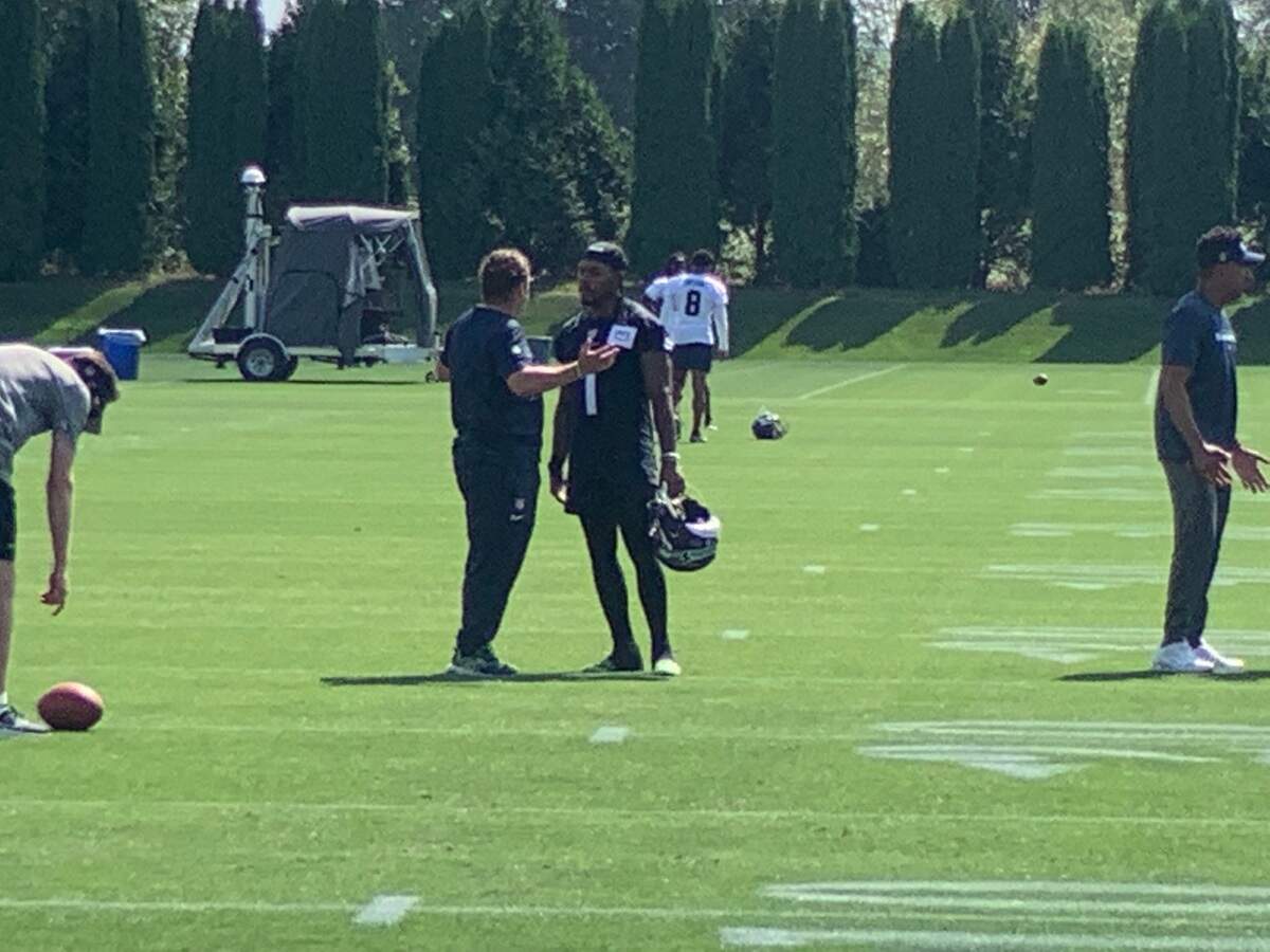 Seahawks general manager John Schneider had a lengthy discussion with wide receiver Dee Eskridge (right) immediately following practice at training camp Sunday, July 30, 2023. The NFL announced Aug. 4 it had suspended Eskridge for the first six games of the 2023 season for violating its personal-conduct policy.