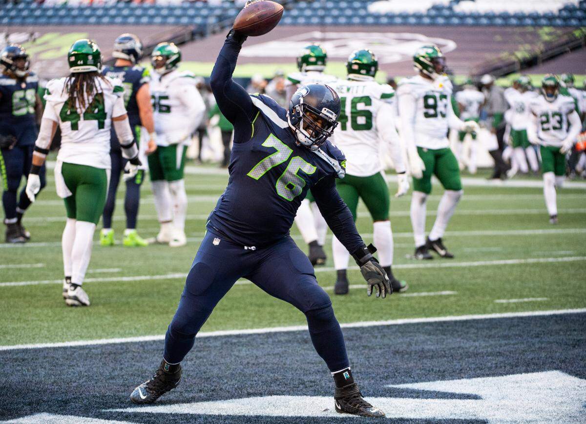 Seattle Seahawks offensive lineman Duane Brown spikes the ball after a touchdown by Seattle Seahawks tight end Will Dissly. The Seattle Seahawks played the New York Jets in a NFL football game at Lumen Field in Seattle, Wash., on Sunday, Dec. 13, 2020.