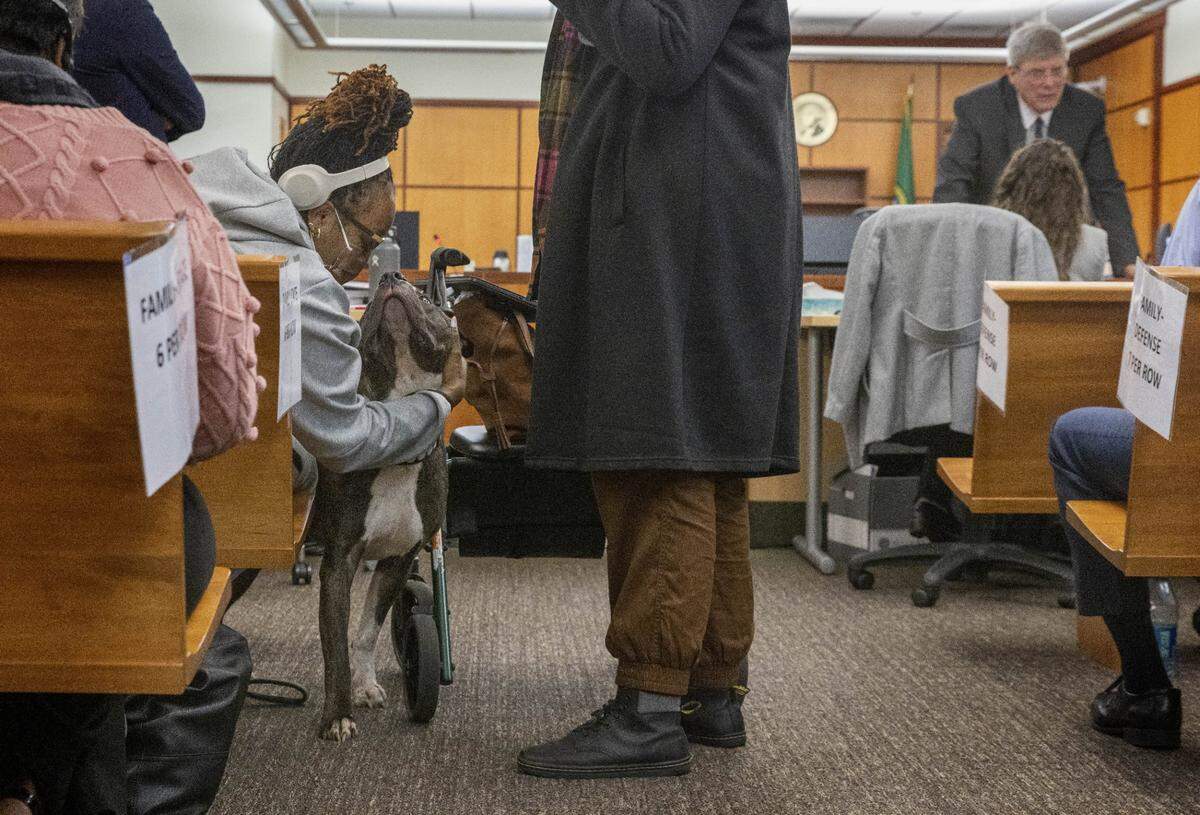 During a break in the trial of three police officers accused of killing Manuel Ellis, Monet Carter-Mixon, sister of Ellis, and her support dog share a moment in Pierce County Superior Court on Nov. 15, 2023, in Tacoma.