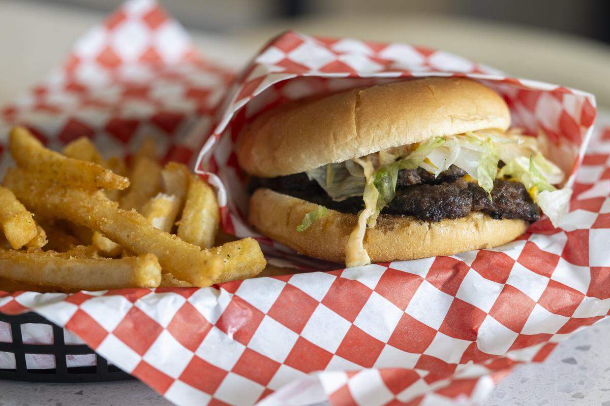 A classic double one-half pound smash burger with cheese is pictured with fries on Wednesday, Oct. 1, 2025, at Secret Burger Kitchen in Tacoma, Wash.