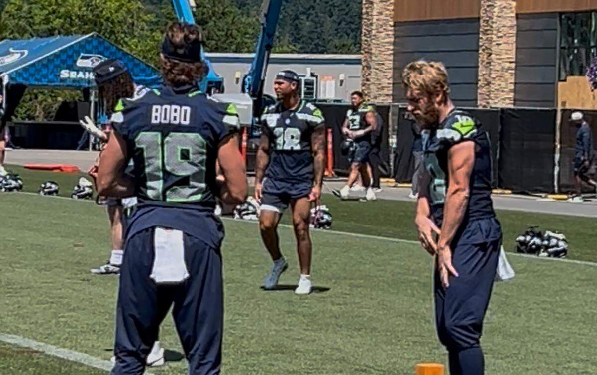 Rookie tight end Elijah Arroyo (18) warms up behind wide receivers Jake Bobo (19) and Cooper Kupp (10, right) at the start of practice in Seattle Seahawks organized team activities (OTAs) June 5, 2025, at the Virginia Mason Athletic Center in Renton.