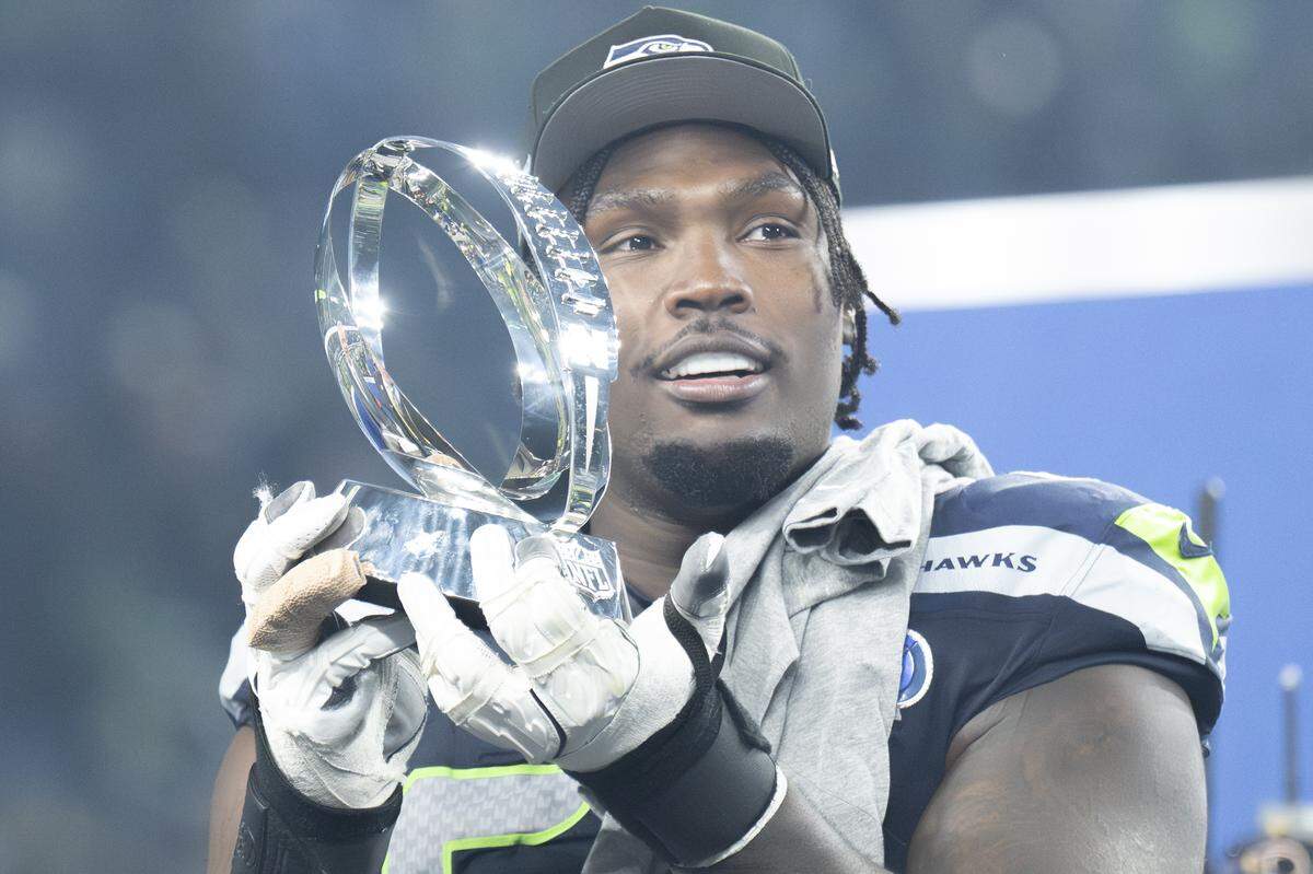 Seattle Seahawks offensive tackle Charles Cross (67) holds the NFC Championship trophy after the team’s win over the Rams at Lumen Field, on Sunday, Jan. 25, 2026, in Seattle.